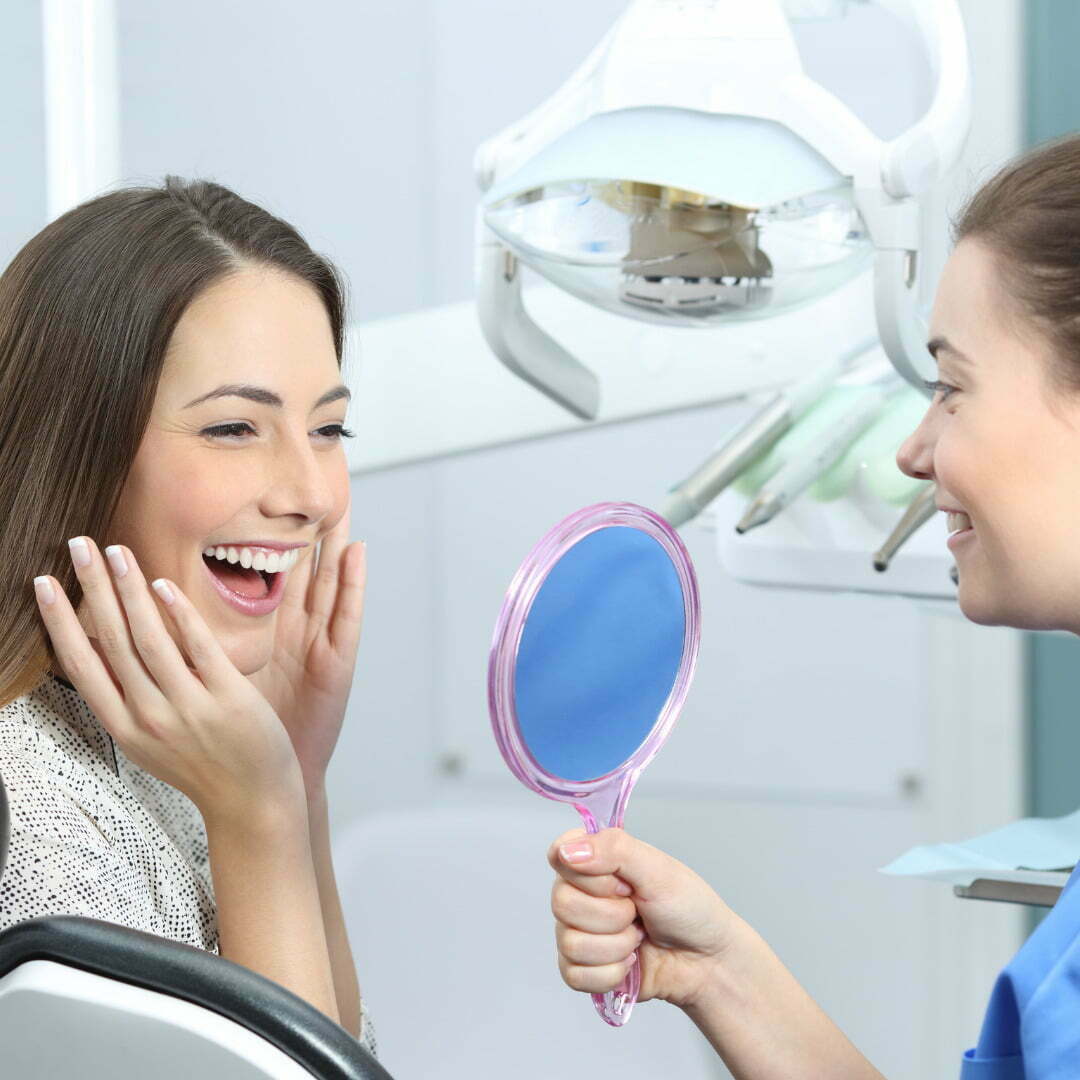 Woman holding mirror to check for white smile
