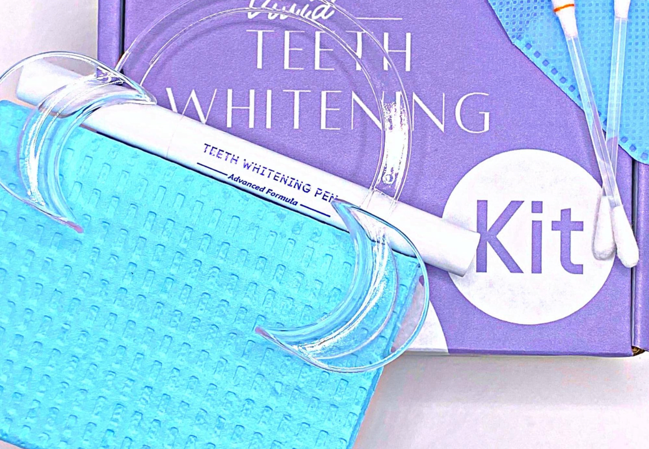 Professional teeth whitening kit with gel pen, cheek retractor, and dental bib.